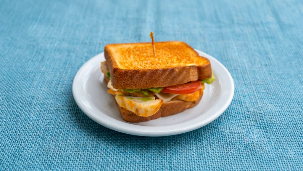 turkey avocado melt on texas toast on a white plate